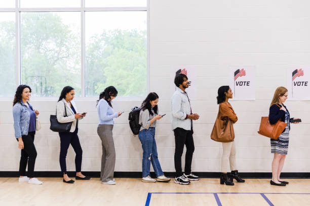 istock Profile view diverse voters lined up by gym wall 1588104988