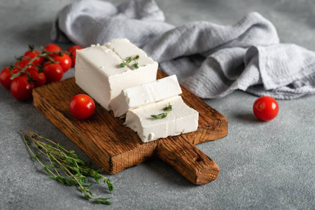 istock Fresh feta cheese with thyme and cherry tomatoes, gray concrete background. Side view, selective focus. 1588107188