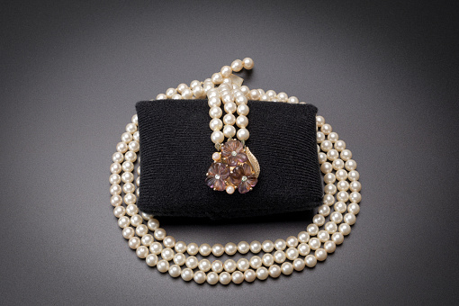 Vintage pearl necklace with diamond studded floral  pendant On a stone background and thought to date around 1890s
