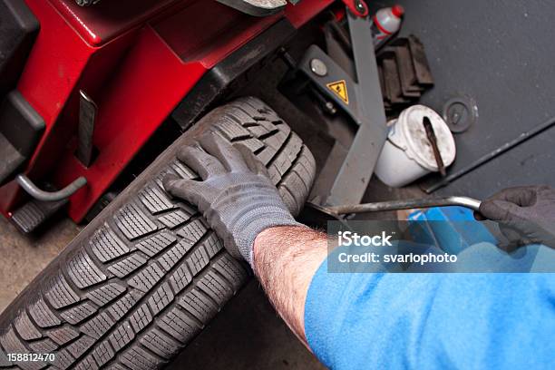 Foto de Mecânico Reparo De Pneu Na Garagem e mais fotos de stock de Adulto - Adulto, Borracha - Material, Carro