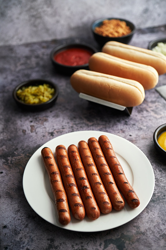 Preparing Hot Dog with Roasted Onions, Pickle Relish, Mustard and Ketchup