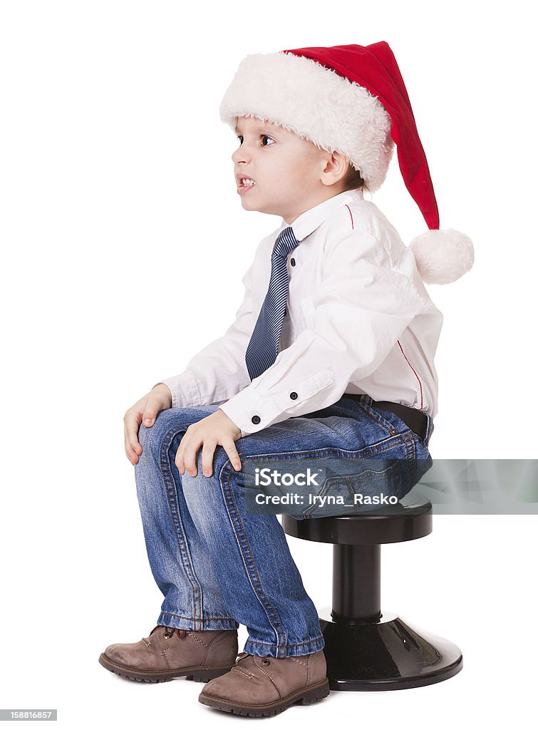 Zła dziecko w santa hat na krześle - Zbiór zdjęć royalty-free (Atak)