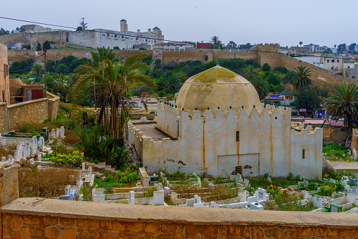 Safi, Morocco - April 08, 2023: View of a cemetery, and the fortress, in Safi, Morocco