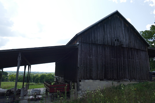 Old weathered wooden barn with agricultural equipment