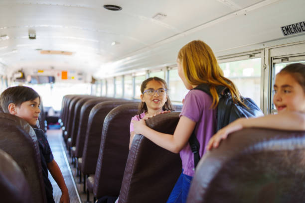 istock Happy kids riding on school bus 1588211375
