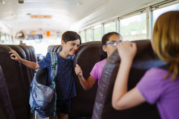 istock Cheerful elementary age boy riding on school bus 1588211899