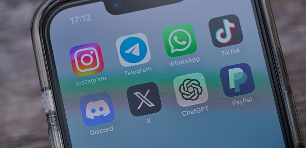 Mainz, Germany - August 02, 2023: close up of iphone on a table showing icons of the apps instagram, telegram, tiktok, twitter, discord, telegram, chatgpt and paypal