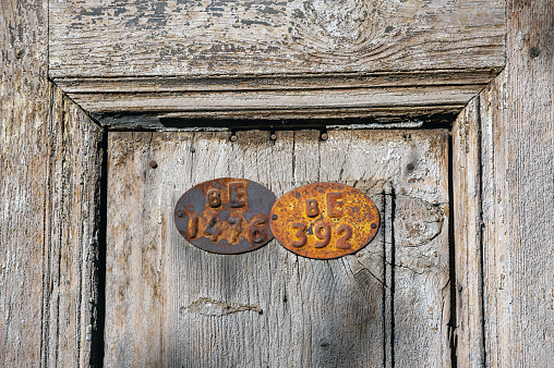 Metal plate numbers on old wooden door