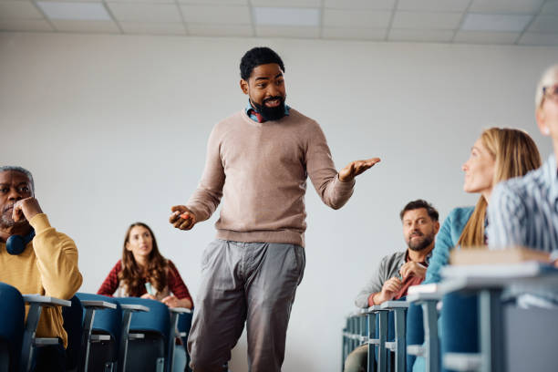istock Black professor teaching group students during adult education training course in lecture hall. 1588286304