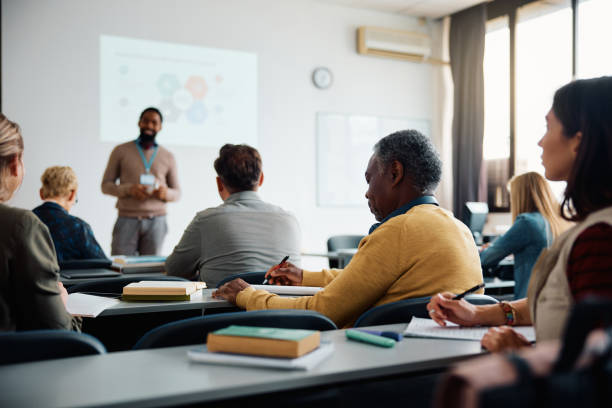 istock Black senior student man writing while attending adult education class in lecture hall. 1588287871