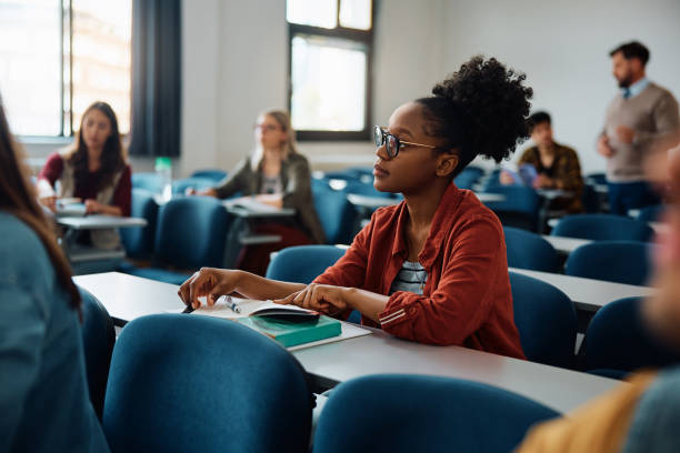 istock Young black student paying attending during a class in lecture hall. 1588288898