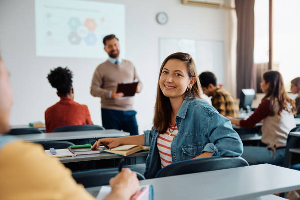 istock Happy college student during a lecture in the classroom looking at camera. 1588289438