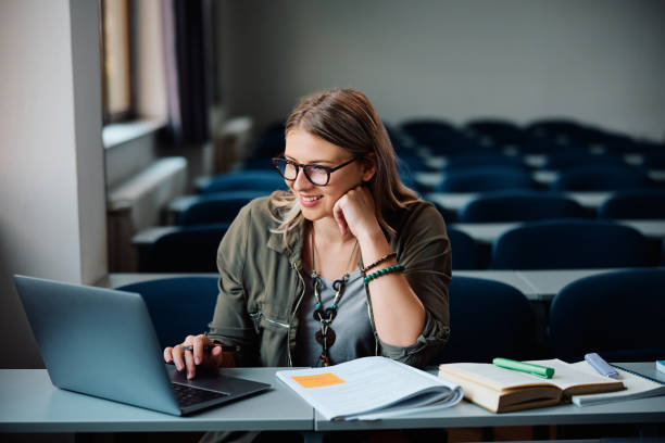 istock Happy female student surfing the net on laptop while learning in the classroom. 1588291028