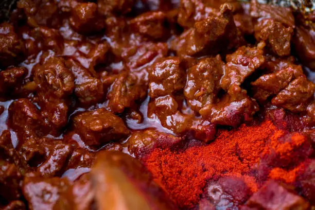 Photo of Traditional goulash soup is cooking in the a cauldron.