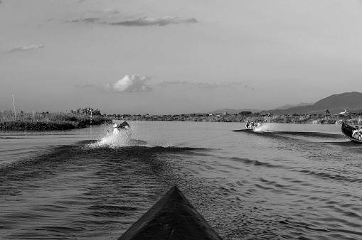 Long tail canoes full of tourists whizzing fast on Inle Lake  at Nyaungshwe
