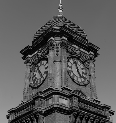 A tall clock tower featuring two clocks on either side of its facade