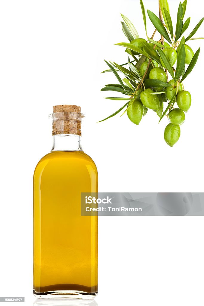 Extra virgin Olive Oil Olive oil in a glass bottle, cork and olive branch with olives study. Bottle Stock Photo