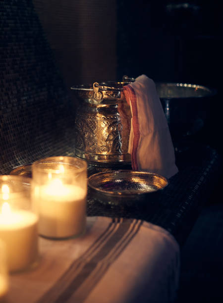 Hamam accessories and candles on a stone table. Massage therapy with candle light. Beauty spa treatment and relax concept.