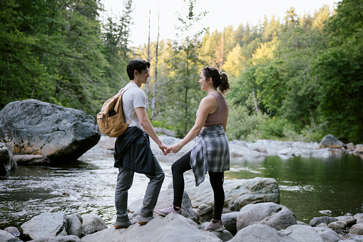 A young couple enjoy a hike through the forest in Washington state, USA.   A relaxing, fun adventure with exercise and beautiful nature views.