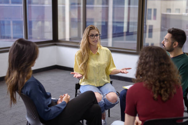 istock Hopeful woman speaking in group therapy session 1588357004