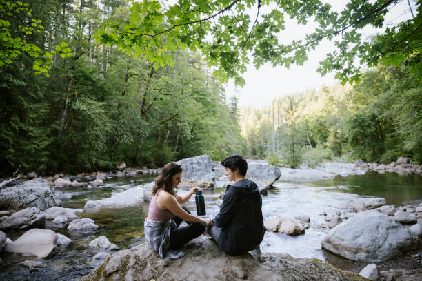 istock Hiking Couple Take Water Break By River 1588364043