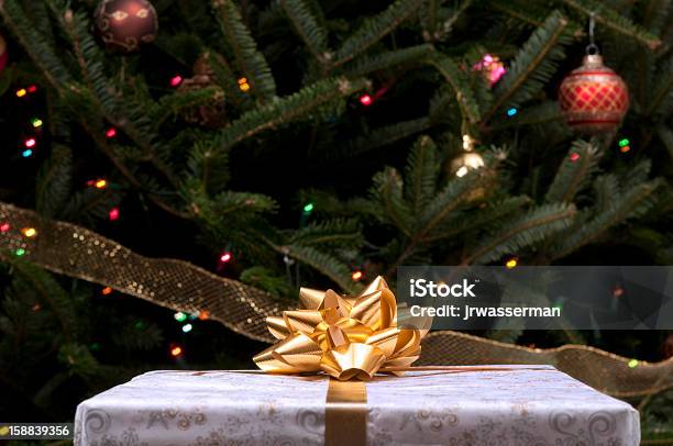 Foto de Presente De Natal Com Tigela De Ouro Em Frente A Árvore e mais fotos de stock de Bola de Árvore de Natal