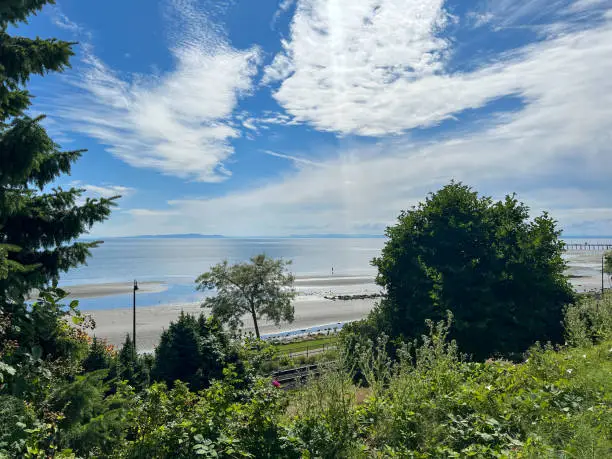 White Rock, British-Columbia, Canada, view on the trees, railroad track, pier, beach, ocean, and sky, summer day