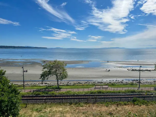 White Rock, British-Columbia, Canada, view on the trees, railroad track, beach, ocean, and sky, low tide, summer day