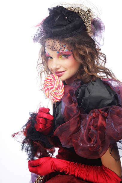 istock Girl with with creative make-up holds lollipop. 1588557591
