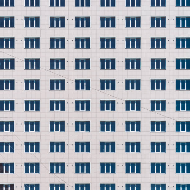 多くのウィンドウ列を持つ幾何学的な背景。シンプルでクラシックなデザインの高層ビル。オフィスビルの現実的なコンセプト。集合住宅のテクスチャ背景。大きな壁の接写に多くの窓。 - architecture classic close up office building ストックフォトと画像