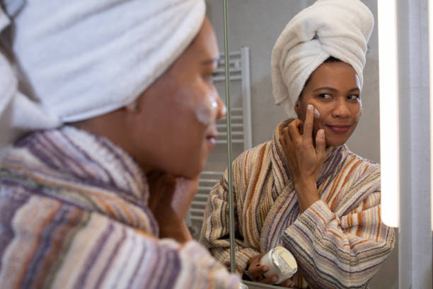 istock Woman applying moisturizer on face 1588571772