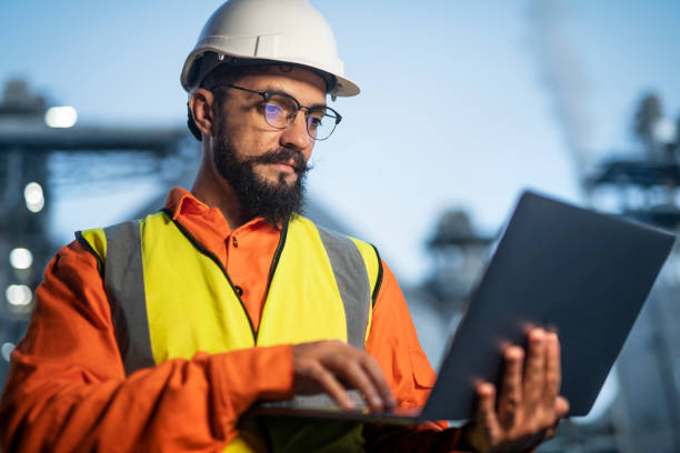istock Engineer using a laptop while working in the oil and gas industry. 1588586172