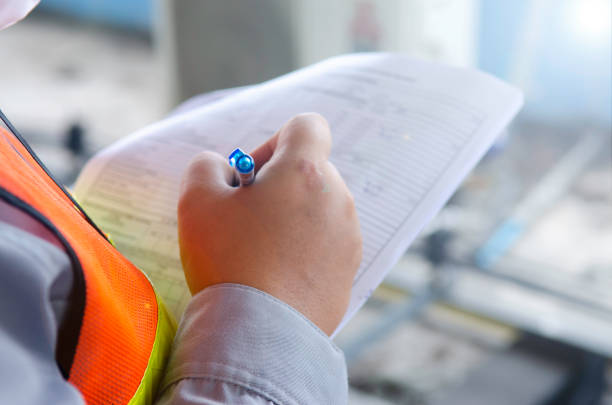 istock Engineer wear safety equipment write and record inspection report 1588623780