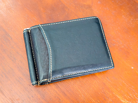 black leather wallet on the wood floor
