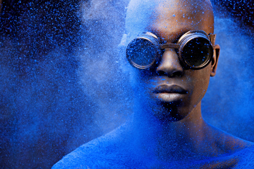 close up of black man covered with blue pigment