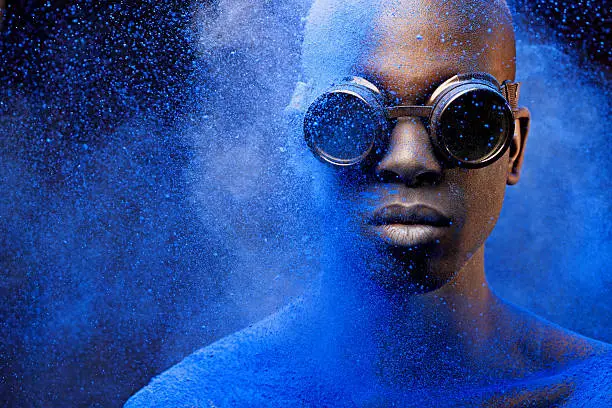 Photo of close up of black man covered with blue pigment