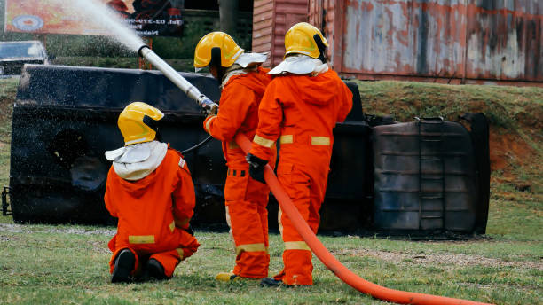 Firefighter Rescue team training in fire fighting extinguisher. Firefighter teamwork fighting with flame using fire hose chemical water foam spray engine. Fireman wear hard hat, safety suit uniform equipo de bomberos de rescate en formación en extintores contra incendios. bomberos en equipo luchando con llamas usando manguera contra incendios química espuma de agua pulverizadora motor. bombero usa casco, uniforme de traje de seguridad