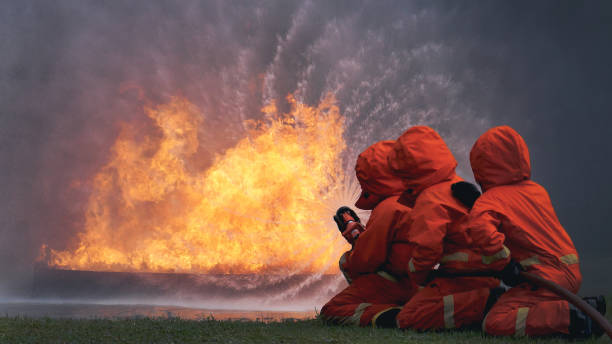 Firefighter Rescue team training in fire fighting extinguisher. Firefighter teamwork fighting with flame using fire hose chemical water foam spray engine. Fireman wear hard hat, safety suit uniform equipo de bomberos de rescate en formación en extintores contra incendios. bomberos en equipo luchando con llamas usando manguera contra incendios química espuma de agua pulverizadora motor. bombero usa casco, uniforme de traje de seguridad