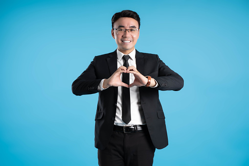 image of young businessman posing on blue background