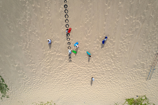 Aerial view of sand, plants, and people on the beach