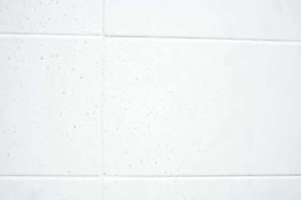 istock drop of water on white tiles wall texture background. 1588726777