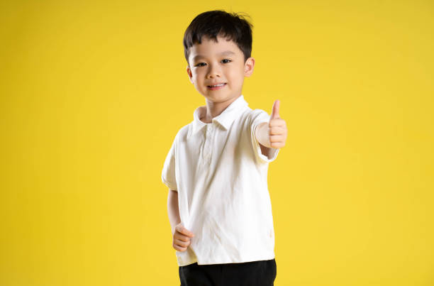 istock image of asian boy posing on a yellow background 1588741733