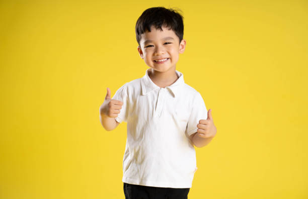 istock image of asian boy posing on a yellow background 1588741734