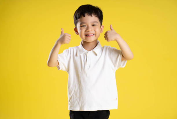 istock image of asian boy posing on a yellow background 1588741735