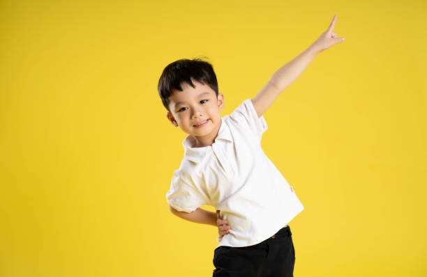 istock image of asian boy posing on a yellow background 1588741742