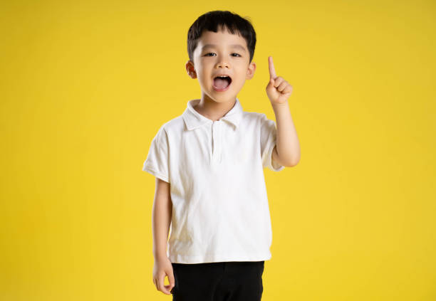 istock image of asian boy posing on a yellow background 1588742262