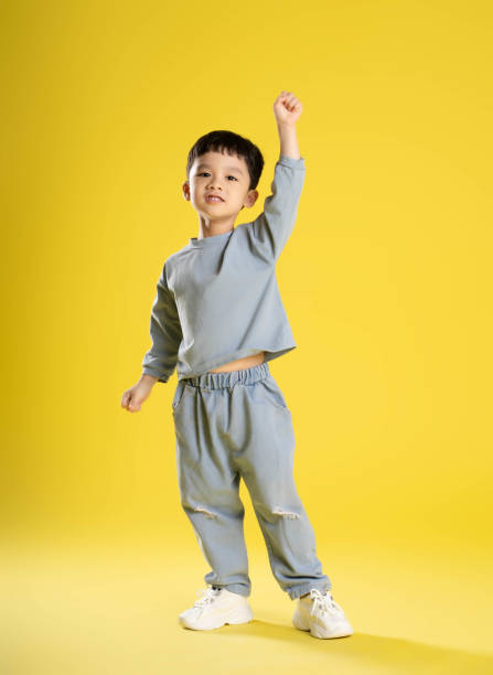 istock full body image of boy posing on a yellow background 1588742777