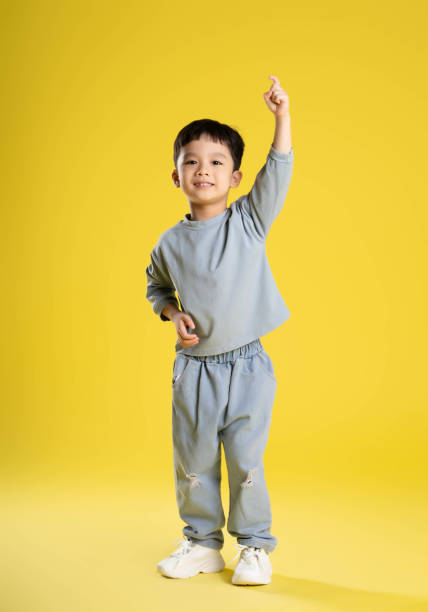 istock full body image of boy posing on a yellow background 1588743300