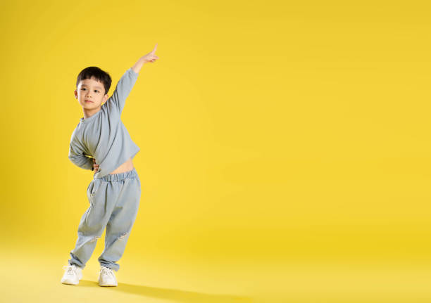istock full body image of boy posing on a yellow background 1588743303