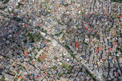 Vertical aerial view of densely populated urban houses and greenery